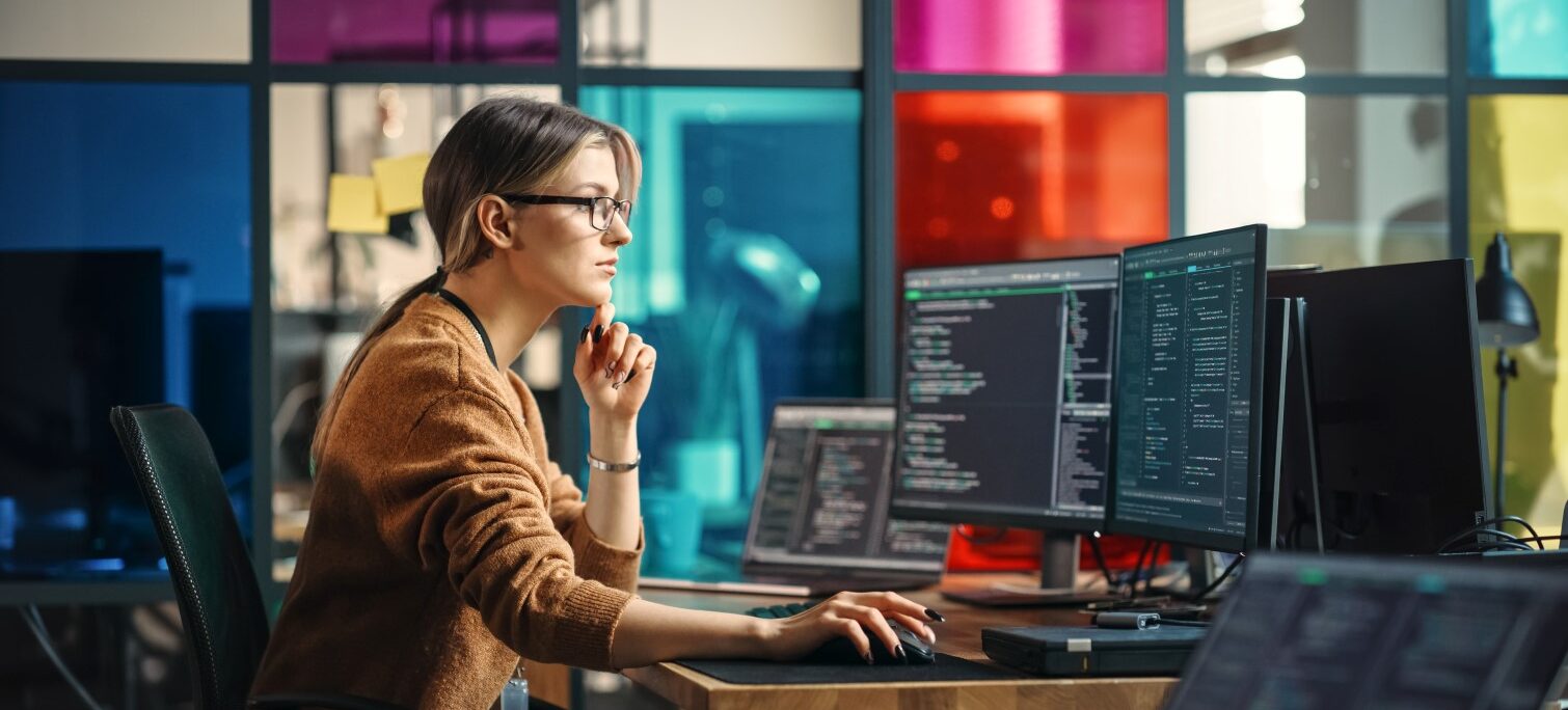 young female worker at computer desk in industrial office space