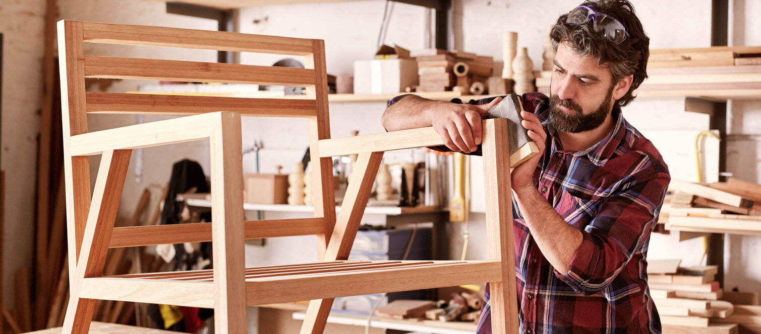 Man assembling wooden chair frame in workshop