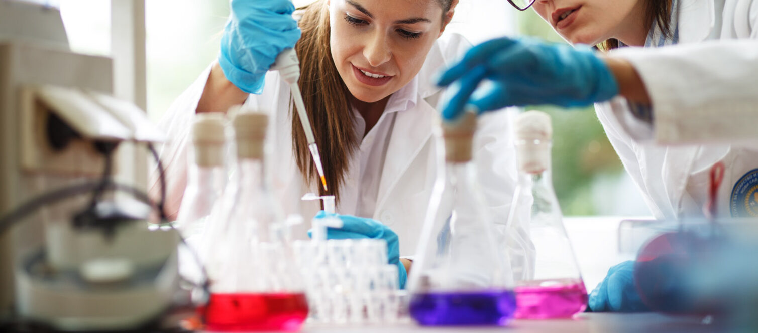 Two dedicated female lab scientists meticulously work together,