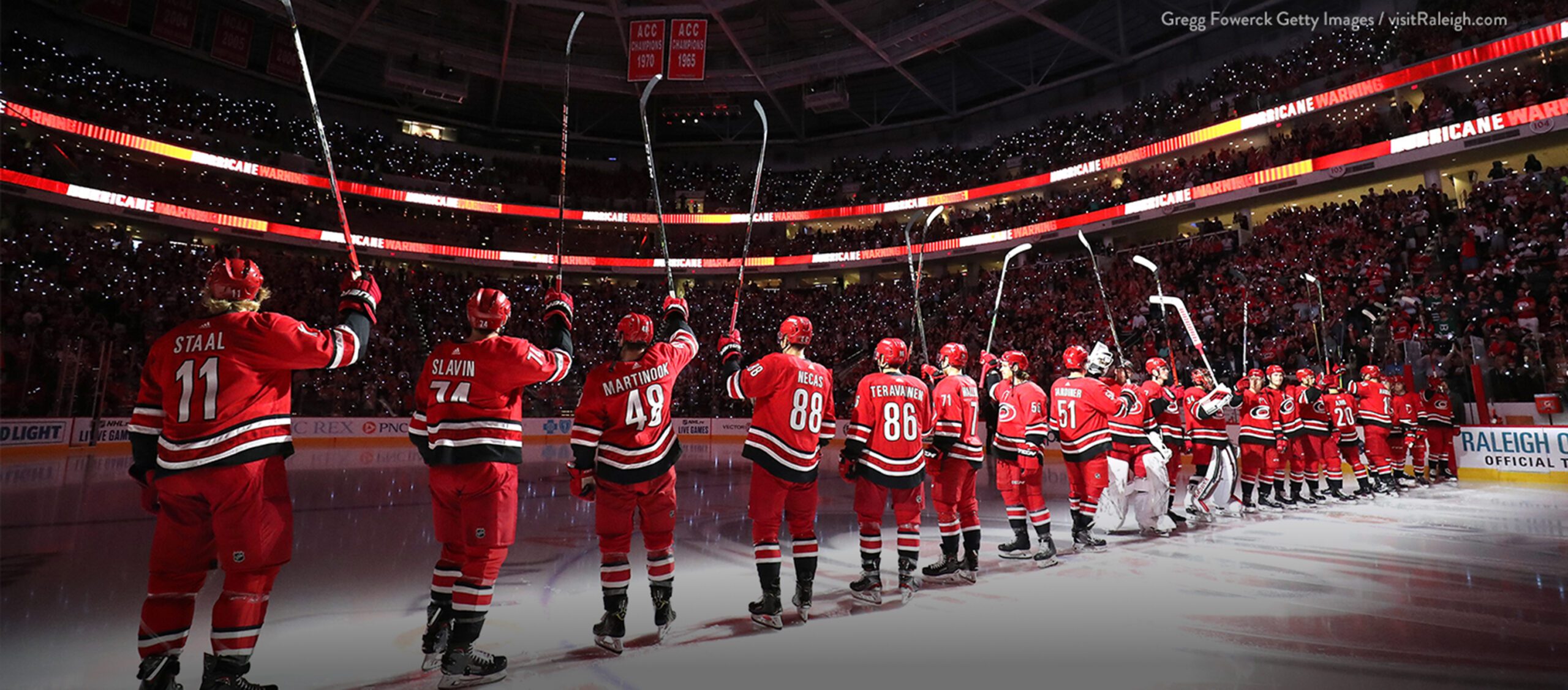 carolina hurricanes players line up on the ice prior to game