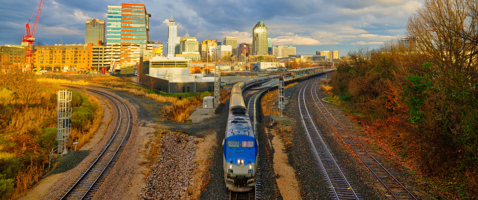 Amtrak train exiting Raleigh station with view of downtown skyline