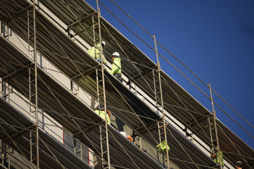 construction workers on side of building