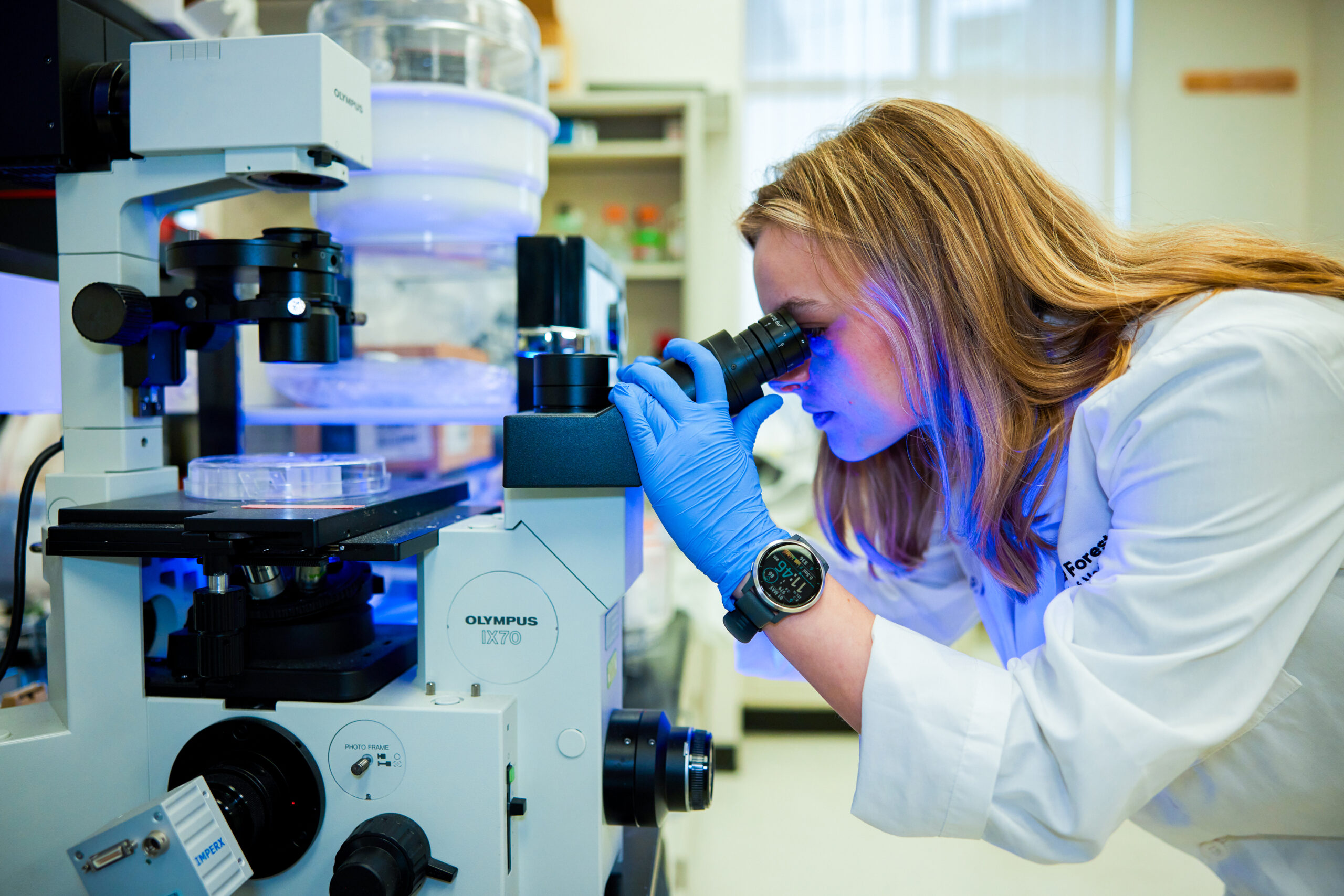 lab worker looking in microscope